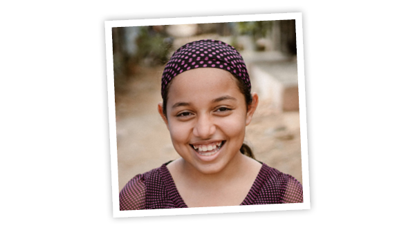 Gesicht eines fröhlich lachenden südamerikanisch aussehenden Mädchens mit einem gepunkteten Tuch im Haar
