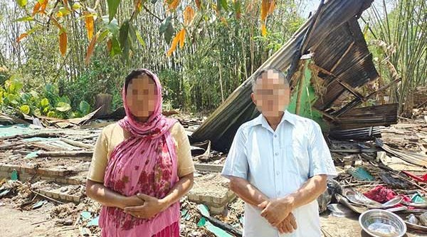 Pastor vom Stamm der Meitei zusammen mit seiner Frau vor den Trümmern ihrer Kirche