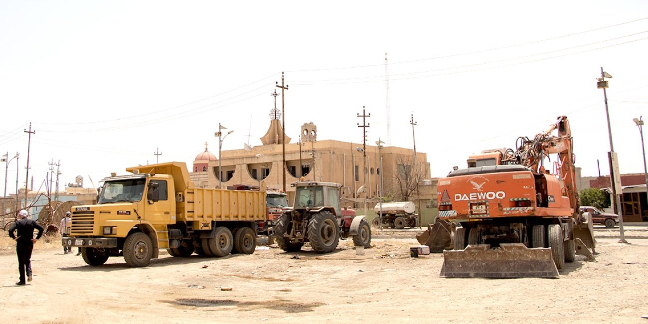 Baustellenfahrzeuge vor der Kirche in Karakosch