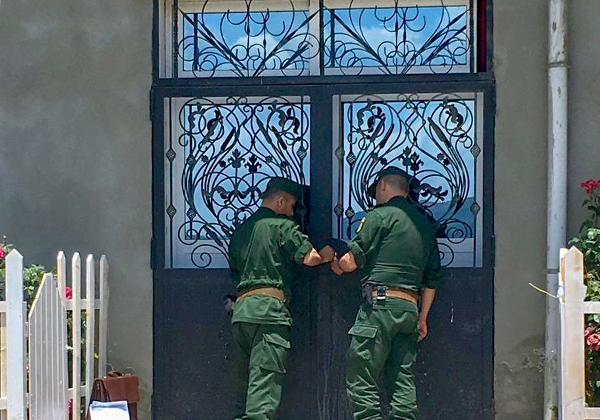 Polizisten beim Versiegeln einer Kirchentür in Algerien