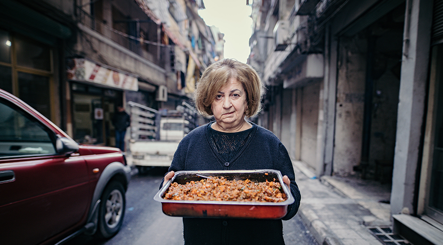 Syrische Frau mit einem Blechkuchen
