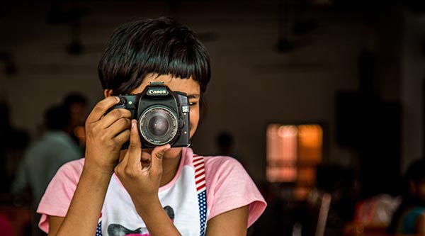 Ein Mädchen mit einer Kamera vor dem gesicht