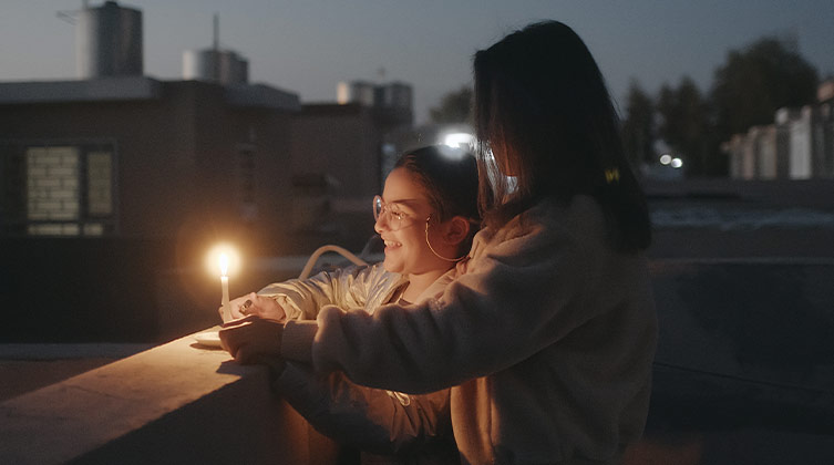 Rafif und ihre Mutter freuen sich am Licht einer Kerze