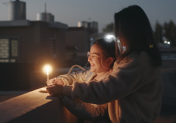 Rafif und ihre Mutter freuen sich am Licht einer Kerze
