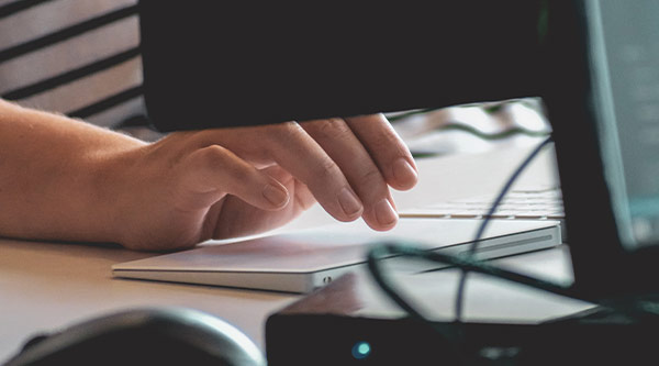 Hand tippt auf Tastatur eine E-Mail ein