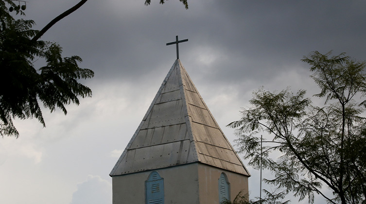 Dunkle Wolken über dem Dach einer Kirche 