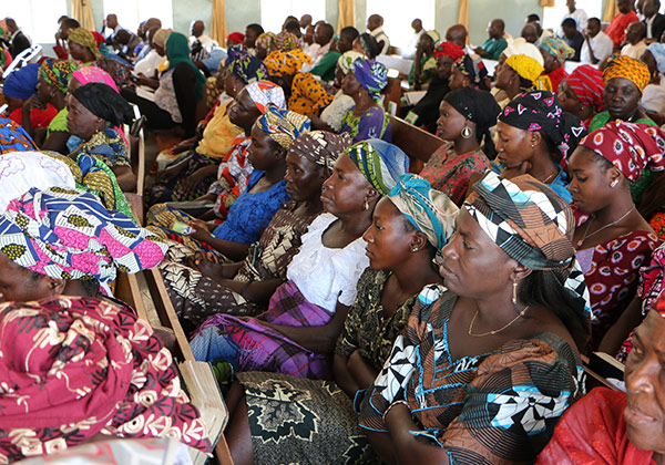 Afrikanische Frauen mit bunter Kleidung sitzen nebeneinander 