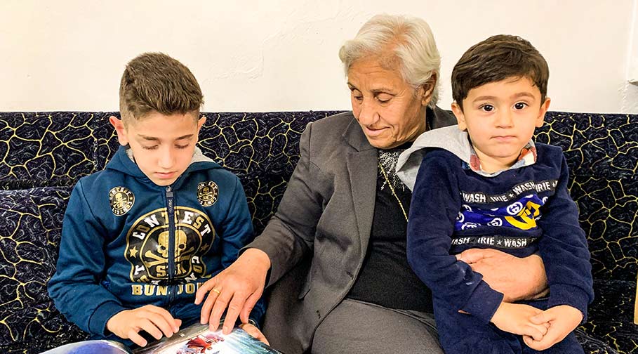 Dschalila aus dem Irak liest mit ihren Enkeln aus der Kinderbibel