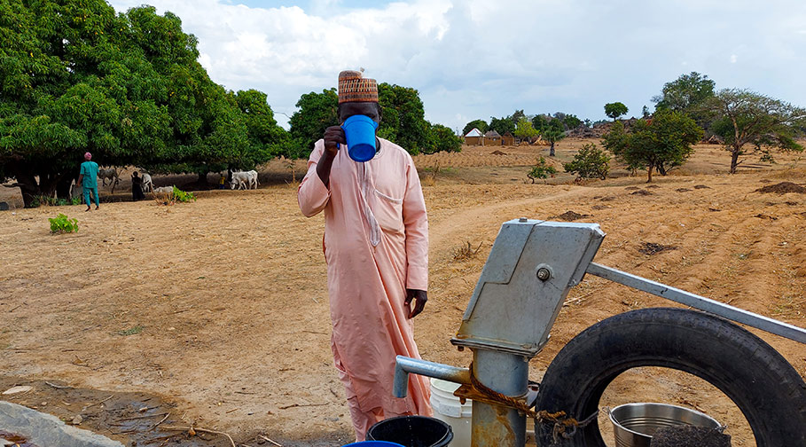 Idi aus Nigeria trinkt Wasser aus dem neuen Brunnen
