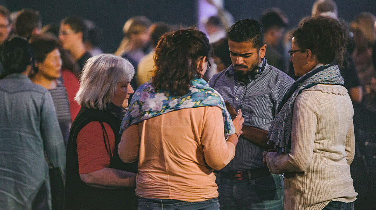 Menschen stehen in kleinen Gruppen im Gebet für verfolgte Christen zusammen