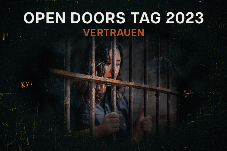 Eine Frau im Gefängnis hält sich an den Gitterstäben fest und schaut traurig nach unten. Open Doors Tag - Vertrauen