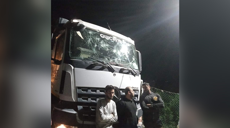 Drei Männer aus Ägypten stehen vor einem beschädigten Lkw