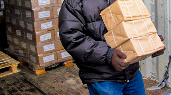 Ein Mann trägt Pakete von einer Palette weg