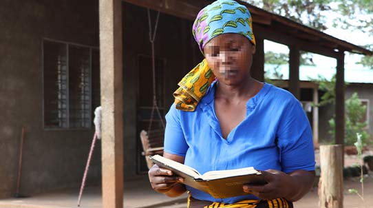Afrikanisch aussehende Frau liest in einem Buch