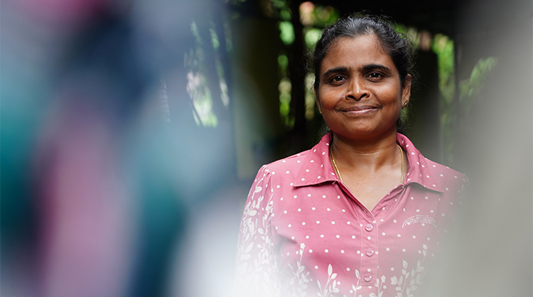 Lächelnde Frau aus Sri Lanka in einer rosafarbenen Bluse