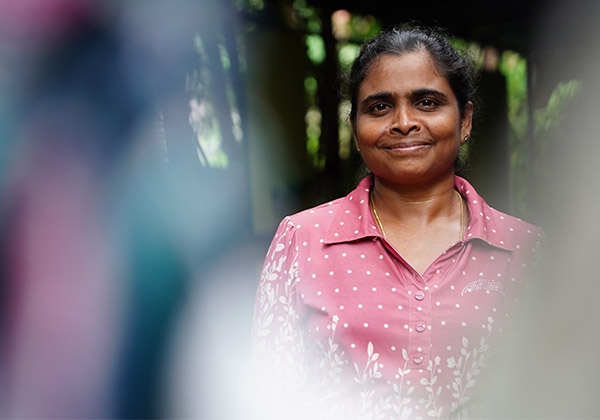 Lächelnde Frau aus Sri Lanka in einer rosafarbenen Bluse