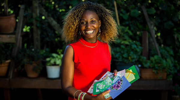 Afrikanische Frau hält Karten in der Hand und lächelt