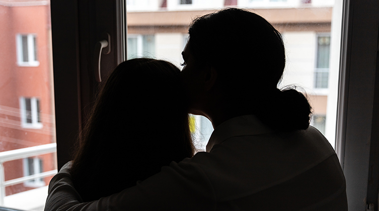 Mutter und Tochter am Fenster stehend