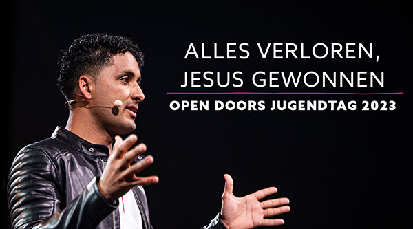 Ein junger Mann mit Lederjacke aus dem Nahen Osten spricht ruhig mit den Händen gestikulierend