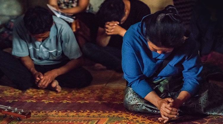 Eine christliche Familie in Laos beim gemeinsamen Gebet