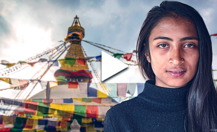 Portrait einer jungen Frau mit Gebetsfahnen im Hintergrund