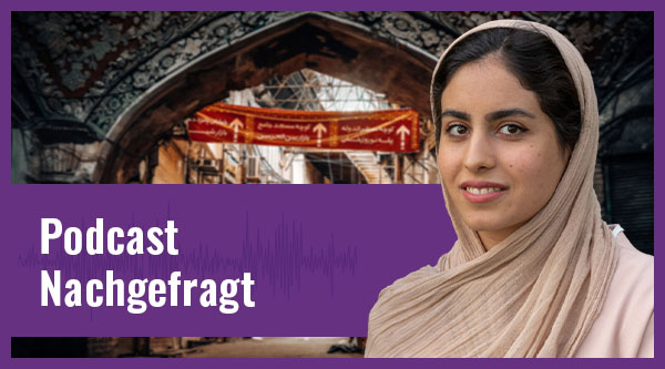 Eine iranische junge Frau mit hellem Schleier und Oberteil lächelt vor einer mit Stromkabeln und Rundbögen befüllten Straße