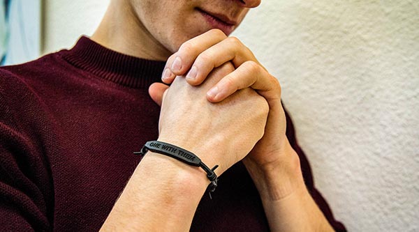 Betende Hände mit One-with-them-Armband