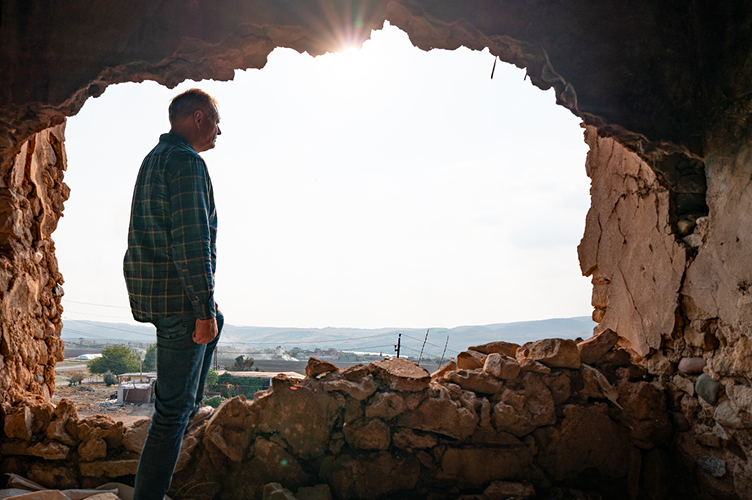 Markus Rode läuft aus der Öffnung eines zerstörten Hauses in helles Licht hinein, davor der Schriftzug des Open Doors Tags 2024 zu Nigeria und Irak