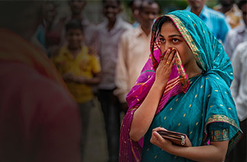 Eine Frau blickt eine Person an und hält sich die Han vor den Mund