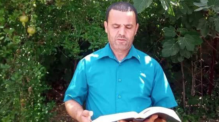 Ein Mann steht mit einem Buch im Freien