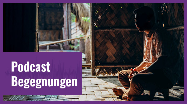 Ein Mann sitzt in einer dunklen Hütte.