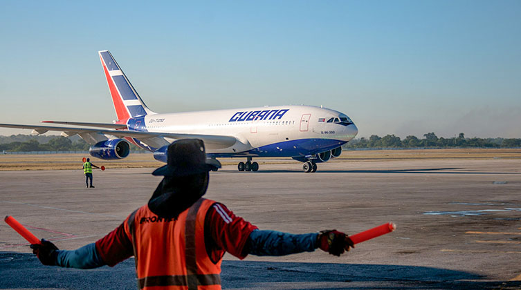 Ein Mann steht am Flughafen und zeigt einem Flugzeug den Weg