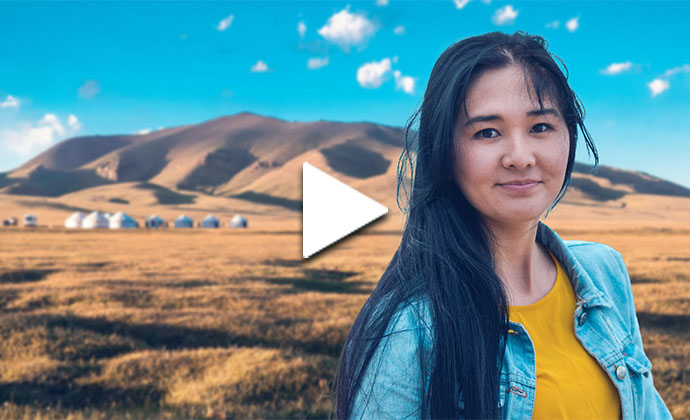 Eine Frau steht vor einer bergigen Landschaft