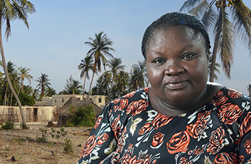 Eine afrikanische Frau vor Wüste und Palmen