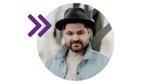 Ein Mann mit Hut schaut in die Kamera