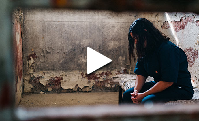 Eine Frau sitzt im Gefängnis und betet