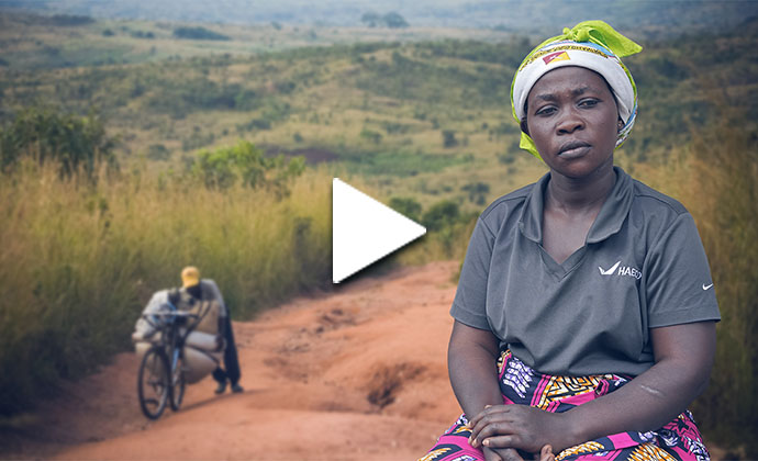 Eine Frau sitzt vor einer hügeligen Landschaft