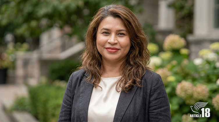 Eine Frau mit braunen Haaren schaut in die Kamera