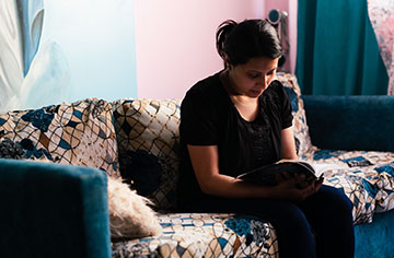 Eine Frau sitzt auf einem Sofa und liest