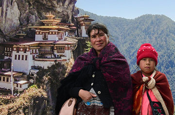 Eine Mutter und ihre Tochter vor einem Tempel in den Bergen Bhutansen, aber mit mutiger Hoffnung und Jesu Botschaft.