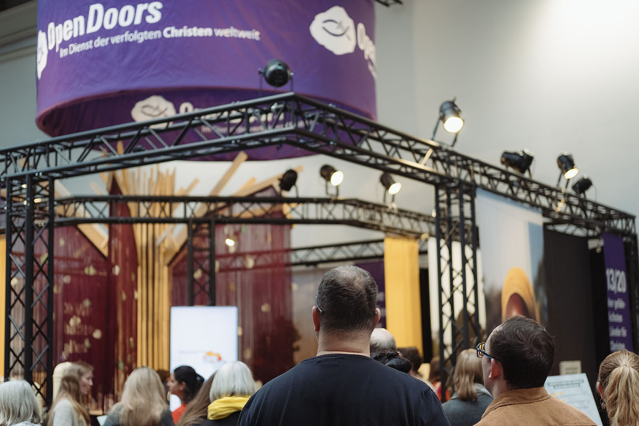 Mehrere Menschen stehen vor einem Open Doors Stand