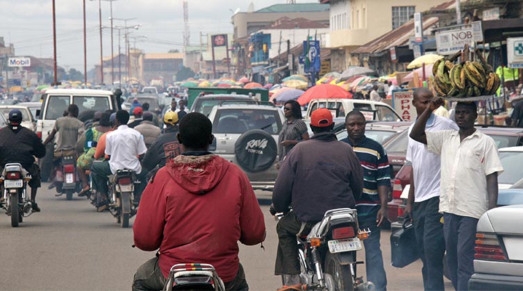 Viele Autos und Motorräder fahren auf einer vollen Straße 