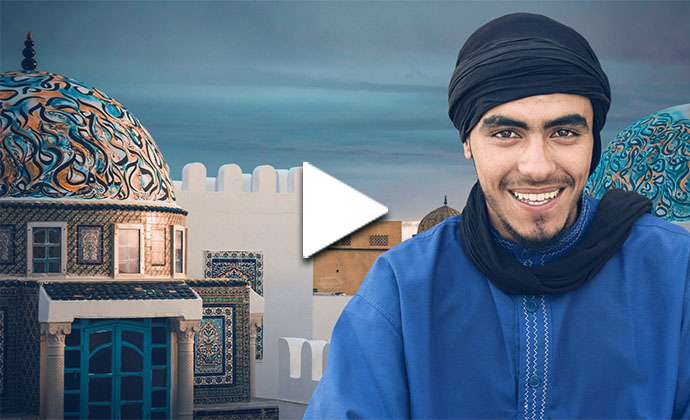 Ein Mann vor einer Moschee lächelt in die Kamera