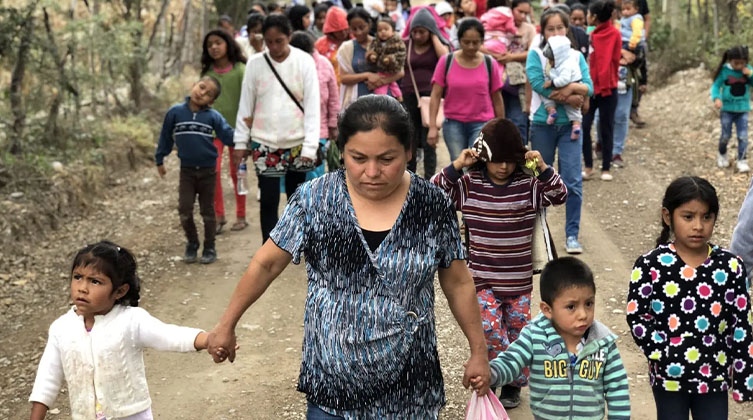Mehrere Frauen und Kinder laufen auf einer Straße