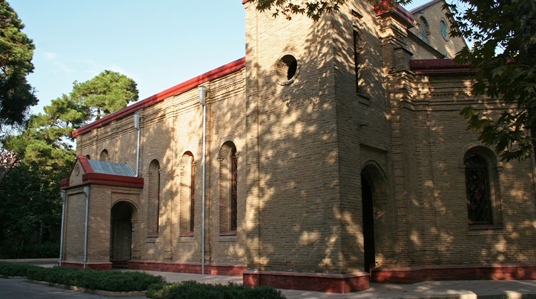 Eine Kirche aus Stein umgeben von Bäumen 