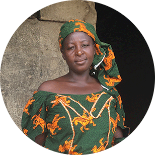 Eine afrikanische Frau in traditionellen Kleidern blickt in die Kamera