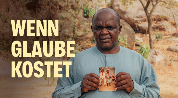 Wenn Glaube kostet | Ein afrikanischer Mann hält ein Foto in beiden Händen und zeigt es in Richtung des Betrachters