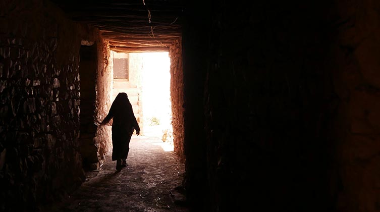 Eine Frau läuft aus einem dunklen Raum nach draußen ins Freie