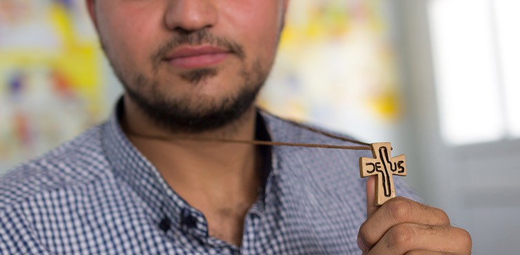 Symbolbild: christlicher Flüchtling mit Kreuz