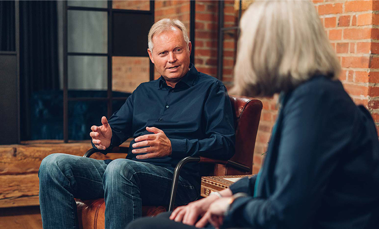 Ein Mann sitzt in einem Interview und gestikuliert